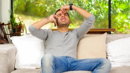 Un hombre habla por teléfono en su casa disgustado