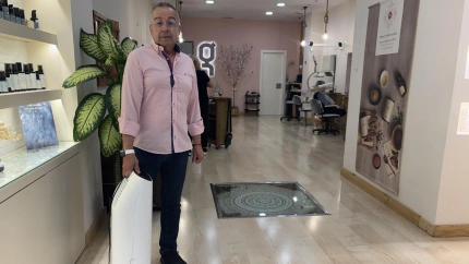 Rafa, peluquero Valenciano, con el purificador de aire para Mónica, vecina de Paiporta