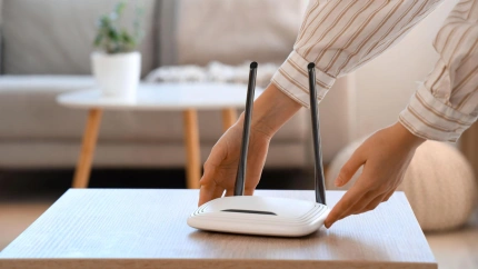 Una mujer coge un router wifi para moverlo y conseguir una mejor conexión