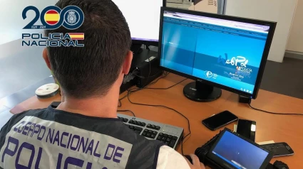 Archivo - Un agente de la Policía frente a un ordenador