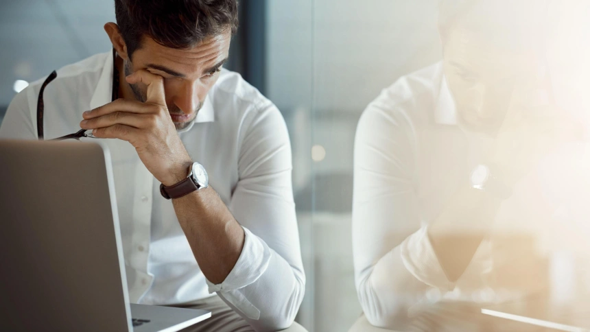 Un hombre estresado y cansado mientras trabaja en la oficina