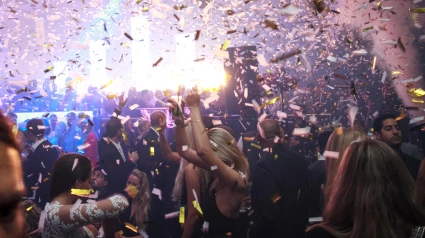 Un cañón lanza confetis en una fiesta dentro de una discoteca