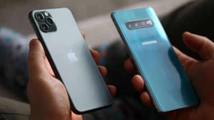 Un hombre sujeta boca abajo dos teléfonos móviles de última generación