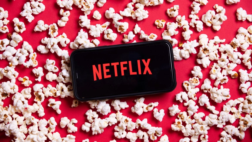 Logo de Netflix en la pantalla de un móvil con palomitas alrededor
