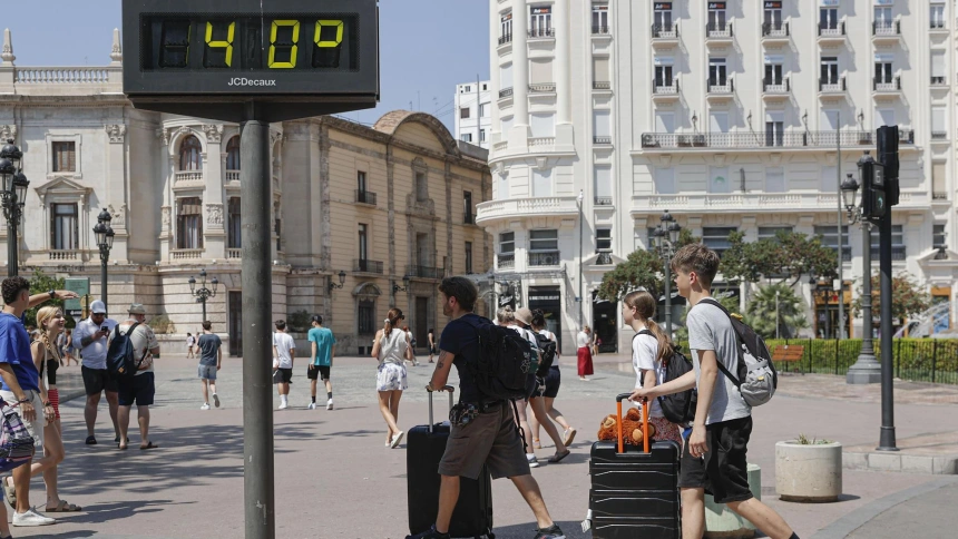 Varios turistas acarrean sus maletas este viernes 15 de agosto por la plaza del Ayuntamiento de València