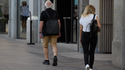 Un señor mayor camina por la calle en Madrid en pleno mes de agosto