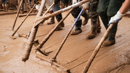 Voluntarios  retirando agua sucia de las calles durante las inundaciones de la DANA