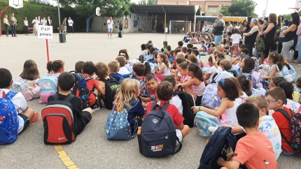 Niños sentados en el patio de un colegio en Lorca