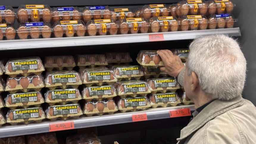 Una persona coge unos huevos en un supermercado