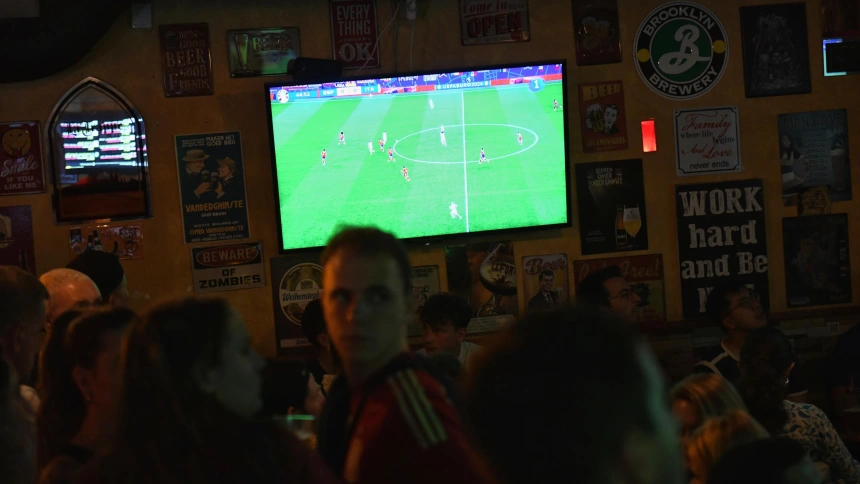 Varios aficionados ven por televisión el partido entre España e Italia.