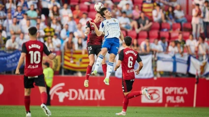 Iván Azón salta en la disputa de un balón aéreo junto a Tomeo, central del Mirandés