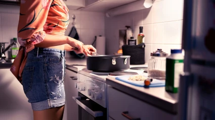 Mujer cocinando de noche