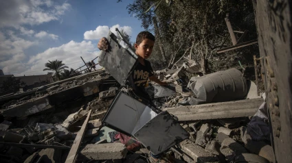 Un niño palestino inspecciona entre los escombros de un edificio destruido tras un ataque aéreo israelí en Deir Al Balah, en el centro de la Franja de Gaza, 4 de octubre de 2024