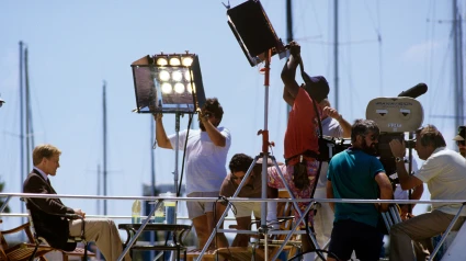 Equipo de producción cinematográfica iluminando una escena.