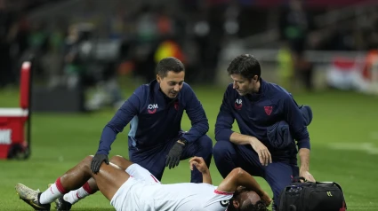 BARCELONA, 20/10/2024.- El delantero del Sevilla Chidera Ejuke (tumbado) es atendido por los servicios médicos del equipo, durante el partido de LaLiga que FC Barcelona y Sevilla FC disputan este domingo en el estadio Lluis Companys. EFE/Alejandro García