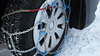 Un coche, en la nieve, con cadenas en las ruedas