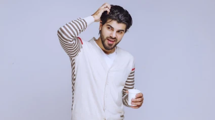 Man in white shirt holding and having a cup of coffee. High quality photo