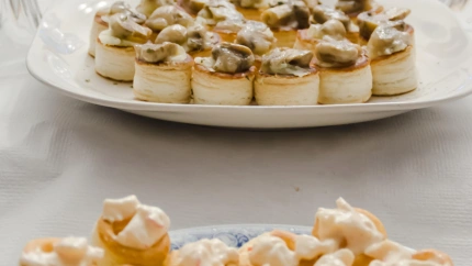 Fotografía de una mesa preparada con vajilla con mucha comida para una cena de fiesta como la de Navidad.
