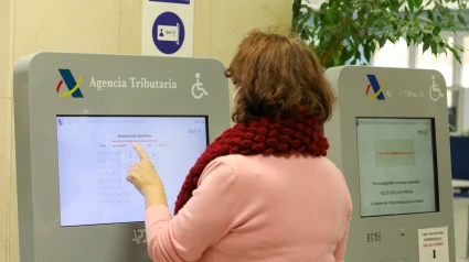 Una mujer recoge su turno en una oficina de la Agencia Tributaria