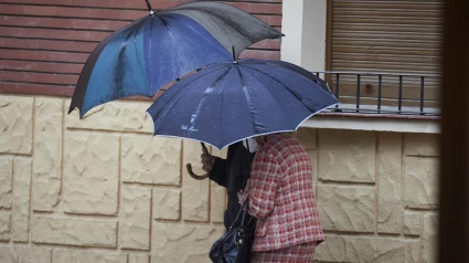 Dos personas se protegen de la lluvia con paraguas