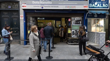 Varias personas hacen cola en la administración de Lotería de Doña Manolita, a 12 de octubre de 2024, en Madrid