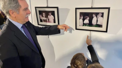 Viso contempla, junto a algunos escolares, las fotografías de la exposición