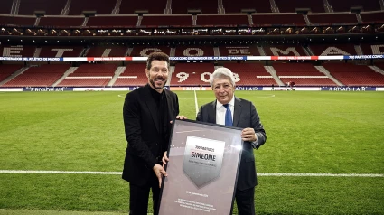 El entrenador del Atlético de Madrid, Diego Simeone, recibe de manos del presidente del Club, Enrique Cerezo, una placa conmemorativa por sus 700 encuentros oficiales al frente del equipo