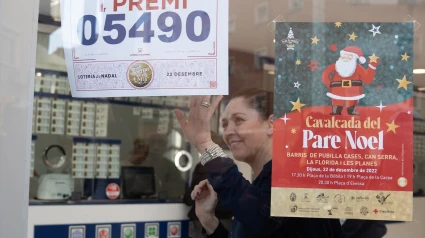 Una empleada de la administración situada en la calle Hierbabuena celebra que han vendido parte del número 5490 correspondiente al 'Gordo' del Sorteo Extraordinario de la Lotería de Navidad, a 22 de diciembre de 2022, en L’Hospitalet de Llobregat, Barcelona, Catalunya