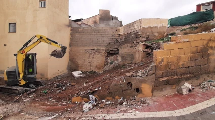 Una pala limpia de basura y escombros el solar que se convertirá en zona verde