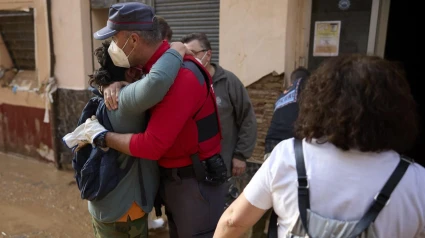 Un policía foral abraza a una vecina de Paiporta durante las labores de cooperación tras el desastre de la DANA