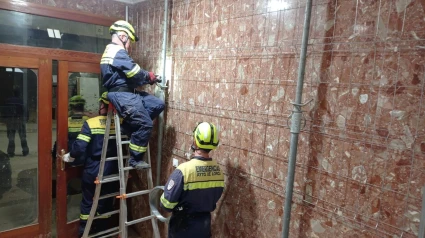 Personal del servicio de Emergencias de Lorca apuntala el zaguán de un edificio en Massanassa