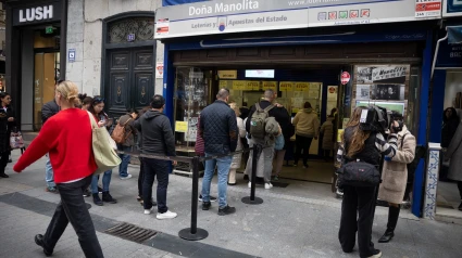 Varias personas hacen cola en la administración de Lotería de Doña Manolita, a 12 de octubre de 2024, en Madrid