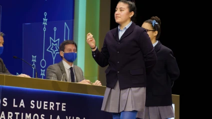 Yanisse Alexandra, una de las niñas de la residencia San Ildefonso, posa minutos después de cantar el primer premio 86.148, durante la celebración del Sorteo Extraordinario de Lotería de Navidad 2021 en el Teatro Real de Madrid