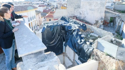 Concejalas y el arqueólogo municipal observan los restos de la torre, preservados con plástico negro