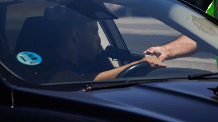 Un agente de la Guardia Civil realiza un control de alcoholemia al conductor de un vehículo durante un control en la autovía A-5,