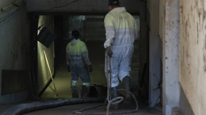 Dos trabajadores con los nuevos dispositivos para la extracción de lodo en garajes en Massanassa