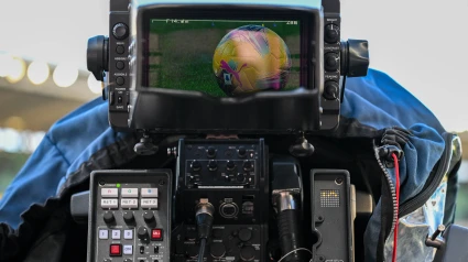 Una cámara de televisión graba durante un partido de fútbol.