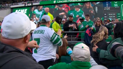 El aficionado que atrapó el balón habla con un miembro de los Eagles.