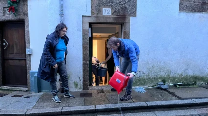 Vecinos de la calle Hortas achicando el agua de sus viviendas