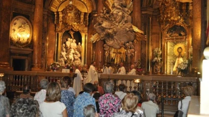 Gente rezando en la Basílica del Pilar