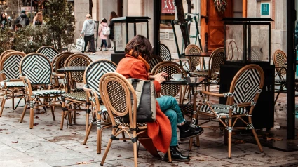 Una acogedora terraza de cafetería o restaurante con mesas y sillas en un día de otoño.