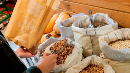 Una clienta se sirve de productos a granel en un supermercado de Gadis