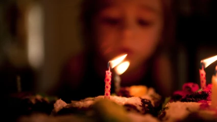 Niña soplando las velas de su tarta de cumpleaños