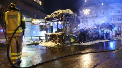 Un bombero junto al autobús calcinado