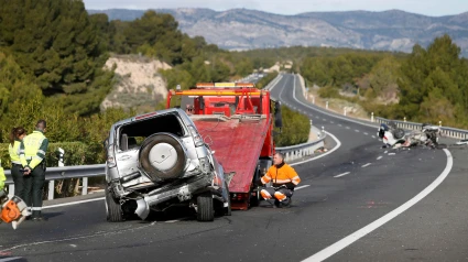 Un operario retira en una grúa uno los vehículos implicados en un accidente en el que han fallecido dos personas y otras dos han resultado heridas, tras una colisión frontal causada por un turismo que circulaba en sentido contrario por la A-7 a la altura de la localidad alicantina de Tibi.