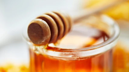 Miel en tarro con cucharón de madera