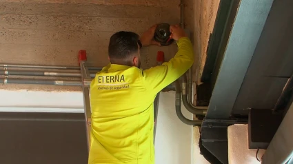 Técnico de Etterna instalando un detector de una alarma