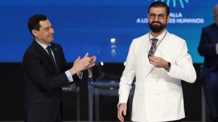 El presidente andaluz, Juanma Moreno, tras imponer la Medalla de Andalucía a los Valores Humanos al humorista y presentador, Manu Sánchez, durante el acto institucional de entrega de las distinciones de Hijo/a Predilecto/a y las Medallas de Andalucía, este viernes en Sevilla. EFE/Julio Muñoz