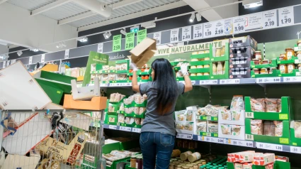 Trabajador de un supermercado Lidl apilando estanterías en una tienda Lidl en España