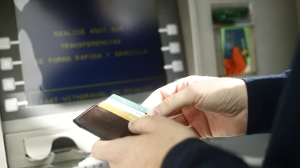 Un hombre retira dinero de un cajero del banco